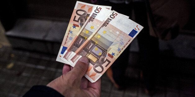 A customer displays three 50 euro banknotes withdrawn from a Banco de Sabadell SA bank branch in Barcelona, Spain, on Friday, Oct. 20, 2017. In a video posted onÂ TwitterÂ late Thursday, the pro-independence Catalan National Assembly urged Catalans to withdraw money from five banks between 8 a.m. and 9 a.m. Friday. Photographer: Angel Garcia/Bloomberg via Getty Images