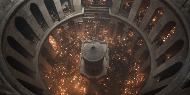 Christian Orthodox worshippers hold candles during the ceremony of the 'Holy Fire' as thousands gather in the Church of the Holy Sepulchre in Jerusalem's Old City, on April 15, 2017, during Orthodox Easter ceremonies.The ceremony celebrated in the same way for eleven centuries, is marked by the appearance of 'sacred fire' in the two cavities on either side of the Holy Sepulchre. / AFP PHOTO / MENAHEM KAHANA (Photo credit should read MENAHEM KAHANA/AFP/Getty Images)