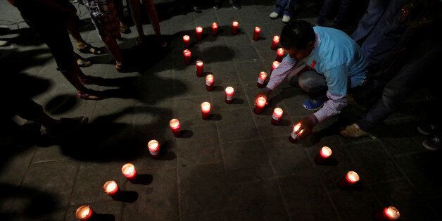 Members of Mexico's HIV/AIDS social organizations light candles during a vigil under the slogan