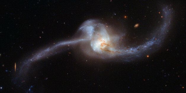 This image, captured by the NASA/ESA Hubble Space Telescope and released October 20, 2017, shows what happens when two galaxies become one. The twisted cosmic knot seen here is NGC 2623 â or Arp 243 â and is located about 250 million light-years away in the constellation of Cancer (The Crab). NGC 2623 gained its unusual and distinctive shape as the result of a major collision and subsequent merger between two separate galaxies. This violent encounter caused clouds of gas within the two galaxies to become compressed and stirred up, in turn triggering a sharp spike of star formation. This active star formation is marked by speckled patches of bright blue; these can be seen clustered both in the centre and along the trails of dust and gas forming NGC 2623âs sweeping curves (known as tidal tails). These tails extend for roughly 50 000 light-years from end to end. Many young, hot, newborn stars form in bright stellar clusters â at least 170 such clusters are known to exist within NGC 2623. NGC 2623 is in a late stage of merging. It is thought that the Milky Way will eventually resemble NGC 2623 when it collides with our neighbouring galaxy, the Andromeda Galaxy, in four billion years time. NASA/ESA Hubble Space Telescope/Handout via REUTERS ATTENTION EDITORS - THIS IMAGE WAS PROVIDED BY A THIRD PARTY