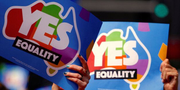 People participating in a march hold aloft posters supporting a 'Yes' vote in a non-binding poll, conducted by post, to inform the government on whether voters want Australia to become the 25th nation to permit same-sex marriage, in central Sydney, Australia, October 21, 2017. Picture taken October 21, 2017. REUTERS/David Gray