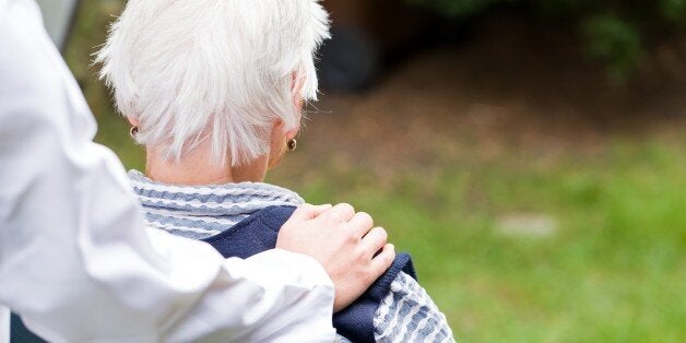 Photo of young carer pushing the elderly woman in wheelchair