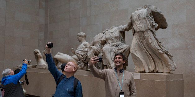 Visitors pose in front of the British Museum's Elgin Marbles that originate from the Parthenon in Athens, on 28th February 2017, in London, England. (Photo by Richard Baker / In Pictures via Getty Images)