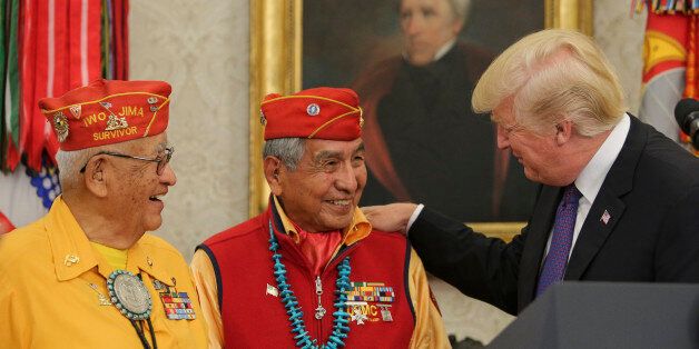 WASHINGTON, DC - NOVEMBER 27: (AFP OUT) U.S. President Donald Trump (R) greets members of the Native American code talkers during an event in the Oval Office of the White House, on November 27, 2017 in Washington, DC. Trump stated, 'You were here long before any of us were here. Although we have a representative in Congress who they say was here a long time ago. They call her Pocahontas.' in reference to his nickname for Sen. Elizabeth Warren. World War II Navajo Code Talker and Iwo Jima survivo