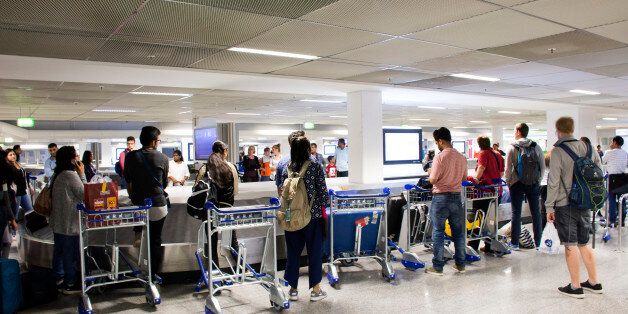 German and foreigner travelers people waiting receive luggage on carousel conveyor at Frankfurt International Airport on August 24, 2017 in Frankfurt, Germany