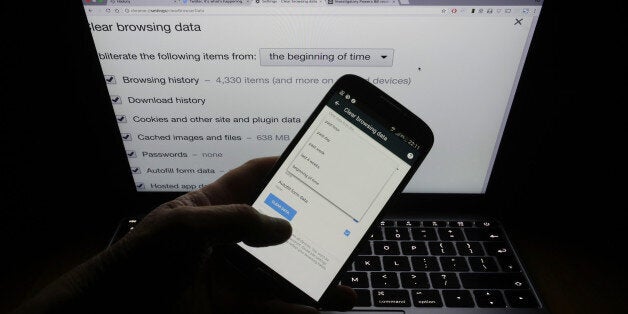 A user looking at both a phone and a laptop screen displaying an option page in the Google Chrome internet browser - allowing users to clear their online browsing data - in London (Photo by Yui Mok/PA Images via Getty Images)