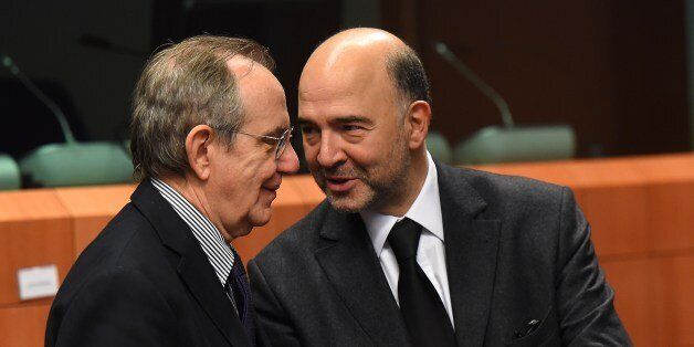 Italian Finance Minister Pier Carlo Padoan (L) and EU economic and financial affairs, taxation and customs commissioner Pierre Moscovici talk on December 8 2014 before the start of a Eurozone finance ministers meeting at EU headquarters in Brussels. AFP PHOTO / EMMANUEL DUNAND (Photo credit should read EMMANUEL DUNAND/AFP/Getty Images)