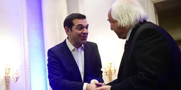 Greek Prime Minister Alexis Tsipras (L) shakes hands with International Politics magazine director Patrick Wajsman, after receiving a prize rewarding political courage, on November 23, 2017 in Paris. / AFP PHOTO / Martin BUREAU (Photo credit should read MARTIN BUREAU/AFP/Getty Images)
