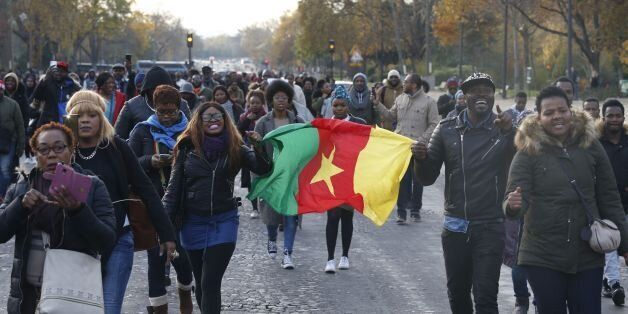 Woman hold a flag of Cameroon during a march against 'slavery in Libya' on November 18, 2017 in Paris. / AFP PHOTO / GEOFFROY VAN DER HASSELT (Photo credit should read GEOFFROY VAN DER HASSELT/AFP/Getty Images)