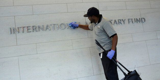 A staff member cleans signage at International Monetary Fund headquarters building during the IMF/World Bank annual meetings in Washington, U.S., October 14, 2017. REUTERS/Yuri Gripas