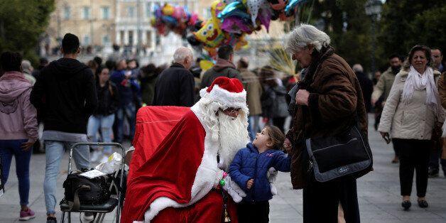 A girl reacts next to a street performer dressed as Santa Claus, on central Syntagma square in Athens, Greece, December 27, 2016. REUTERS/Alkis Konstantinidis