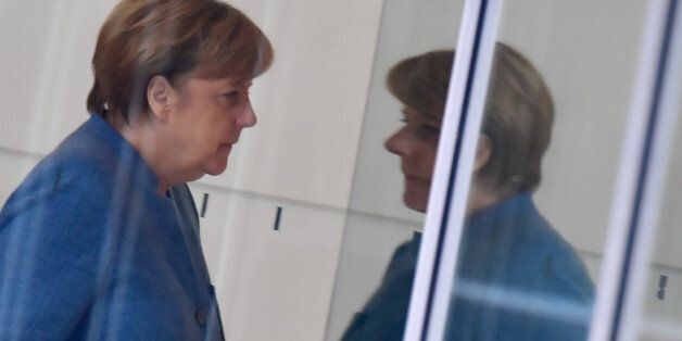 German Chancellor Angela Merkel, also leader of the conservative Christian Democratic Union (CDU) party, reflects in a window as she walks from one room to another during exploratory talks with members of potential coalition parties to form a new government on November 7, 2017 in Berlin. / AFP PHOTO / John MACDOUGALL / ALTERNATIVE CROP (Photo credit should read JOHN MACDOUGALL/AFP/Getty Images)