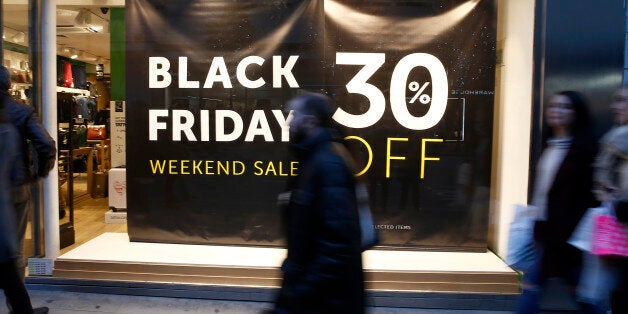 Shoppers walk past a store promoting