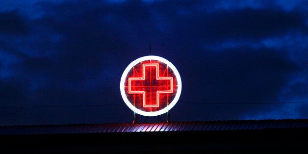 A red neon cross is seen on the rooftop of the Evangelismos State General Hospital in Athens May 30, 2012. Greece's rundown state hospitals are cutting off vital drugs, limiting non-urgent operations and rationing even basic medical materials for exhausted doctors as a combination of economic crisis and political stalemate strangle health funding. With Greece now in its fifth year of deep recession, trapped under Europe's biggest public debt burden and dependent on international help to keep paying its bills, the effects are starting to bite deeply into vital services. Picture taken May 30, 2012. REUTERS/Yorgos Karahalis (GREECE - Tags: BUSINESS HEALTH SOCIETY) ATTENTION EDITORS: PICTURE 03 of 25 FOR PACKAGE 'GREEK HEALTH SYSTEM CRUMBLES'. SEARCH 'RUNDOWN STATE HOSPITALS' TO FIND ALL IMAGES