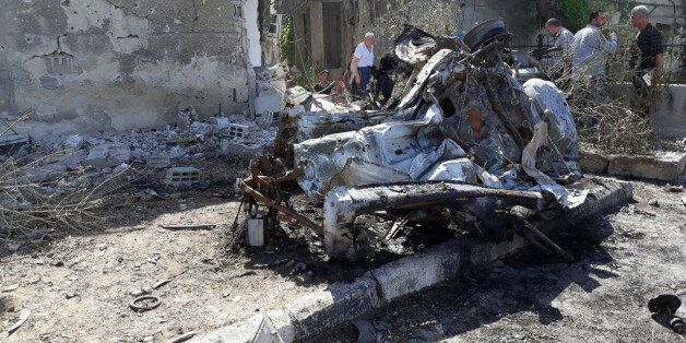 People inspect the site of a car bomb blast in Damascus in this handout picture posted on SANA on July 2, 2017, Syria. SANA/Handout via REUTERS ATTENTION EDITORS - THIS PICTURE WAS PROVIDED BY A THIRD PARTY. REUTERS IS UNABLE TO INDEPENDENTLY VERIFY THE AUTHENTICITY, CONTENT, LOCATION OR DATE OF THIS IMAGE