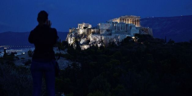 A woman takes pictures of the ancient Acropolis in Athens on October 2, 2017. Greece's economy will rebound with 2.4-percent growth in 2018, and narrowly meet primary surplus targets, according to the government's latest draft budget on October 2. / AFP PHOTO / LOUISA GOULIAMAKI (Photo credit should read LOUISA GOULIAMAKI/AFP/Getty Images)