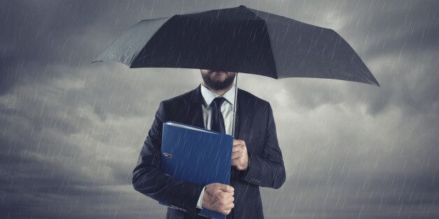 Businessmen with umbrella standing in stormy rain.Insurance agent and consultant in business crisis situation.