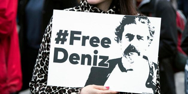 A woman attending a concert for the International Press Freedom Day holds a banner reading 'Free Deniz' in front of the Brandenburg Gate in Berlin, Germany on May 3, 2017. The concert expresses solidarity to all jailed journalists everywhere in the world and in particular to the German-Turkish journalist of the German newspaper 'Die Welt' Deniz Yucel, which is incarcerated in Turkey since February 2017. (Photo by Emmanuele Contini/NurPhoto via Getty Images)