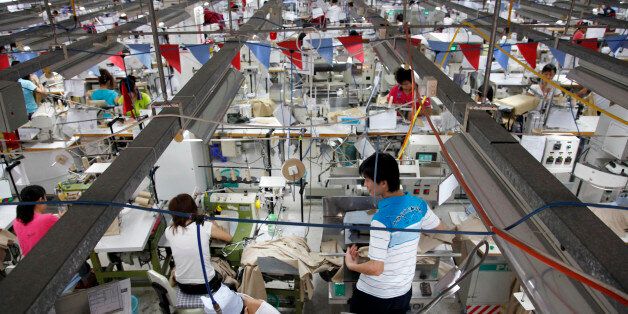 Close to a thousand employees, mostly women, work side by side on a production floor at a Textile Alliance Apparel factory in Qingxi Township, Dongguan, Guangdong Province, China, on July 28, 2010. The factory supplies shirts and pants to major brands such as J Crew, Hugo Boss, Burberry, etc and produces over 300,000 shirts per day (Photo by In Pictures Ltd./Corbis via Getty Images)