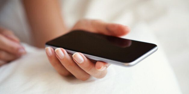 Woman using smartphone in bed