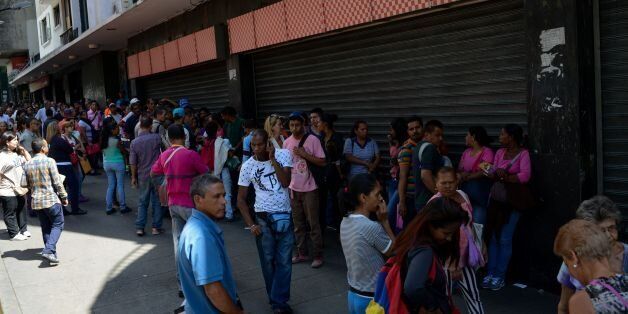 People queue outside a supermarket in Caracas to buy basic foodstuffs and household products on November 10, 2017.In crisis-stricken Venezuela, the cost of the basic basket of goods soared to nearly 2.7 million bolivars in September, the equivalent of six minimum monthly wages. / AFP PHOTO / FEDERICO PARRA (Photo credit should read FEDERICO PARRA/AFP/Getty Images)