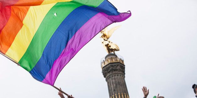 Participants celebrate on top of a truck as one waves the pride rainbow flag, with the city's Victory Coumn in the back. Thousands of participants marched in the streets of Berlin under heavy rain to celebrate Christopher Street Day as part of the city's pride week, July 22, 2017. (Photo by Omer Messinger/NurPhoto via Getty Images)