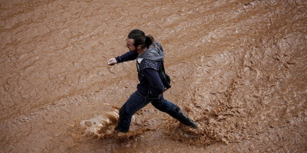 ATHENS, Nov. 15, 2017 : A man walks in a flooded street following a heavy rainfall in the town of Mandra, Greece, Nov. 15, 2017. The death toll from the flash floods that hit the outskirts of Athens is feared to rise in the coming hours after five deaths and seven injuries were confirmed by the government on Wednesday. (Xinhua/Marios Lolos via Getty Images)
