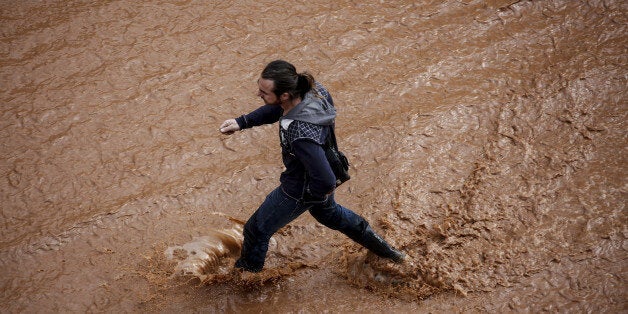 ATHENS, Nov. 15, 2017 : A man walks in a flooded street following a heavy rainfall in the town of Mandra, Greece, Nov. 15, 2017. The death toll from the flash floods that hit the outskirts of Athens is feared to rise in the coming hours after five deaths and seven injuries were confirmed by the government on Wednesday. (Xinhua/Marios Lolos via Getty Images)