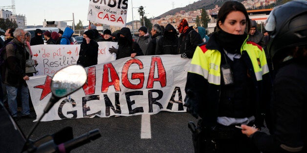 A Catalan regional policewoman (Mossos d'Esquadra) talks to rides as picketers block the nudo de la Trinidat access road to Barcelona on November 8, 2017 as part of a regionwide strike called by a pro-independence union. / AFP PHOTO / PAU BARRENA (Photo credit should read PAU BARRENA/AFP/Getty Images)