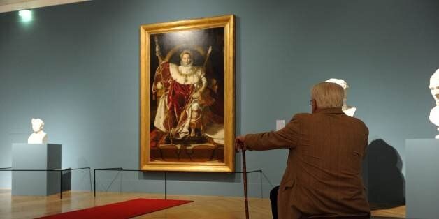 A visitor sits in front of the painting 'Napoleon on his Imperial Throne' (1806) by French painter Jean Auguste Dominique Ingres presented at the 'Napoleon and Europe' exhibition at the Bundeskunsthalle Bonn, western Germany, on January 11, 2011. The exhibition, taking place from December 17, 2010 to April 25, 2011, is displaying 400 artworks from sculpture to portraits from different artists and shows the positive and negative aspects of the work of Napoleon Bonaparte in Europe. AFP PHOTO P