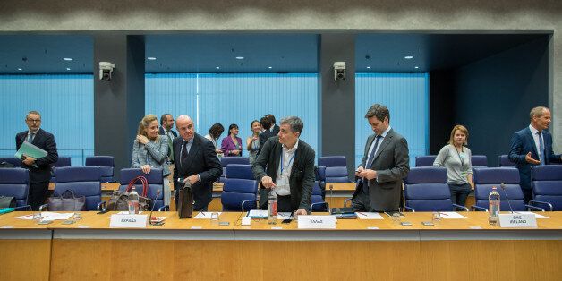 Euclid Tsakalotos, Greece's finance minister, center, prepares to take his seat as Luis de Guindos, Spain's finance minister, center left, looks on ahead of a Eurogroup meeting of European finance ministers in Luxembourg on Thursday, June 15, 2017. Euro area finance ministers plan to disburse EU8.5b bailout tranche for Greece, two officials familiar with the matter say, asking not to be named, pending final decision. Photographer: Jasper Juinen/Bloomberg via Getty Images