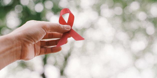 red aids ribbon in hand.