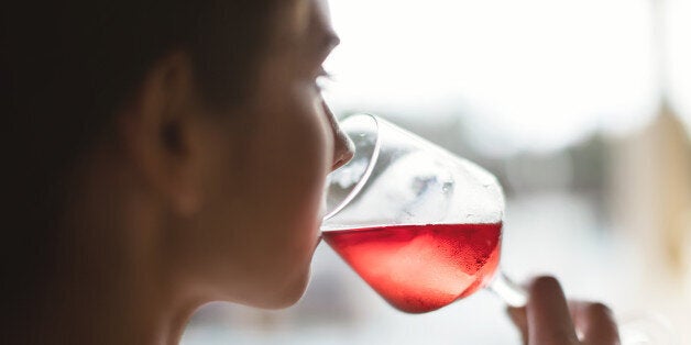 Woman drinking rose wine, light effect, side view