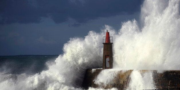 Waves crash against a lighthouse in Viavelez, northern Spain, January 21, 2015. REUTERS/Eloy Alonso (SPAIN - Tags: SOCIETY)