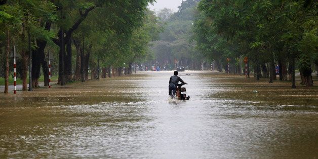 A man pushes his motorcycle along flooded road after typhoon Damrey hits Vietnam in Hue city, Vietnam November 5, 2017. REUTERS/Kham