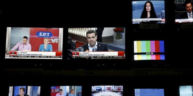 Greek Prime Minister Alexis Tsipras is seen on a monitor screen (C) at the control room during the first broadcast of state television ERT after its reopening in Athens June 11, 2015. Employees at Greece's state television ERT hugged each other and cried on Thursday as the channel aired its first broadcast in two years, after it was shut down under one of the previous government's most drastic austerity measures. Leftist Prime Minister Alexis Tsipras, who is racing to reach a cash-for-reforms de