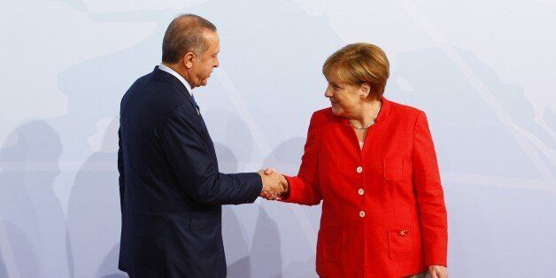 HAMBURG, GERMANY - JULY 07: German Chancellor Angela Merkel (R) welcomes Turkish President Recep Tayyip Erdogan (L) for a family photo taking during G20 (Group of 20) leaders' summit in Hamburg, Germany on July 7, 2017. Germany is hosting leaders from the worlds 20 largest economies at the Hamburg summit on July 7-8, set to focus on the global economy, trade, climate change, and the fight against international terrorism. (Photo by Michele Tantussi/Anadolu Agency/Getty Images)
