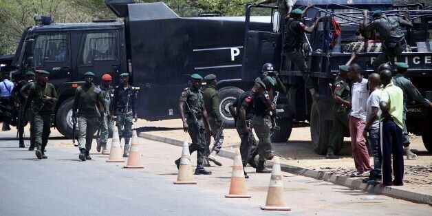 Nigerian security forces take position as students protest outside the South African Digital Satellite TV's (DSTV) Nigerian headquarters in Abuja against the recent spike in attacks targeting foreign nationals in South Africa on February 23, 2017. / AFP / PHILIP OJISUA (Photo credit should read PHILIP OJISUA/AFP/Getty Images)