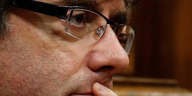 Catalan President Carles Puigdemont listens to Junts pel Si spokesperson Lluis Corominas (unseen) during a plenary session at the Catalan regional Parliament in Barcelona, Spain, October 27, 2017. REUTERS/Albert Gea