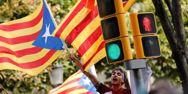 A man waves an 'Esteladas' (Catalan pro-independence flags) during a protest in front of the Economy headquarters of Catalonia's regional government in Barcelona on September 20, 2017Thousands took to the streets of Barcelona as Spanish police detained 13 Catalan government officials in a crackdown ahead of an independence referendum which Madrid says is illegal. With tensions mounting, separatist organisations called for more people to protest as leaders in the northeastern region pressed ahead with preparations for the October 1 vote despite Madrid's ban and a court ruling deeming it unconstitutional. / AFP PHOTO / PAU BARRENA (Photo credit should read PAU BARRENA/AFP/Getty Images)