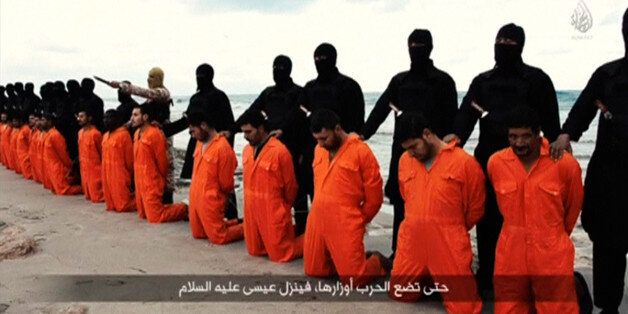 Men in orange jumpsuits purported to be Egyptian Christians held captive by the Islamic State (IS) kneel in front of armed men along a beach said to be near Tripoli, in this still image from an undated video made available on social media on February 15, 2015. Islamic State released the video on Sunday purporting to show the beheading of 21 Egyptian Christians kidnapped in Libya. In the video, militants in black marched the captives to a beach that the group said was near Tripoli. They were forc