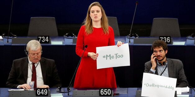 European Parliament member Terry Reintke (C) holds a placard with the hashtag