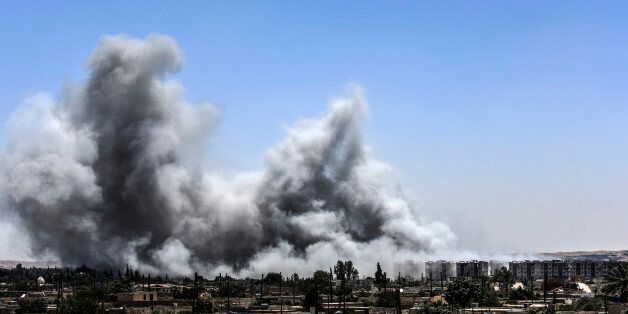 Smoke billows following an airstrike on the western frontline of Raqa on July 15, 2017, during an offensive by the Syrian Democratic Forces (SDF), an alliance of Kurdish and Arab fighters, to retake the city from Islamic State (IS) group fighters.The US-backed coalition has captured around 30 percent of Raqa city since it entered the IS bastion in June after a months-long operation to capture territory in the surrounding province. / AFP PHOTO / BULENT KILIC (Photo credit should read BULENT KILIC/AFP/Getty Images)