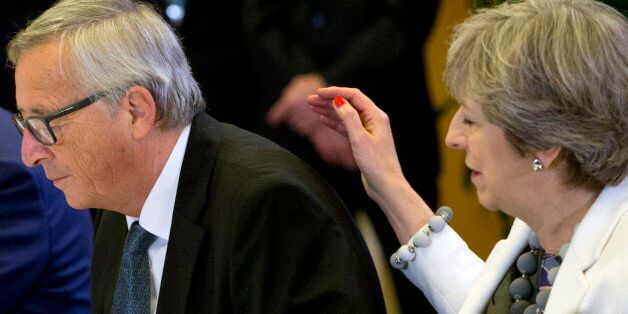 Britain's Prime Minister Theresa May (R) places her hand on the back of European Commission President Jean-Claude Juncker during a breakfast meeting at on the second day of a summit of European Union (EU) leaders in Brussels on October 20, 2017.The EU is expected to say that they will start internal preparatory work on a post-Brexit transition period and a future trade deal with Britain. / AFP PHOTO / POOL / Virginia Mayo (Photo credit should read VIRGINIA MAYO/AFP/Getty Images)