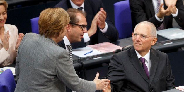 BERLIN, GERMANY - OCTOBER 24: Newly-elected Bundestag President Wolfgang Schaeuble (R) receives the congratulations of German Chancellor Angela Merkel (L) shortly after he was elected at the opening session of the new Bundestag on October 24, 2017 in Berlin, Germany. Today's is the first session since German federal elections in September. The new Bundestag is markedly different from the previous one, as instead of four parties the new parliament contains six, including approximately 90 parliamentarians of the right-wing Alternative for Germany (AfD). Meanwhile the German Christian Democrats (CDU/CSU), the Free Democratic Party (FDP) and the German Greens Party (Buendnis 90/Die Gruenen) are continuing their negotiations for forming a government coalition. (Photo by Carsten Koall/Getty Images)