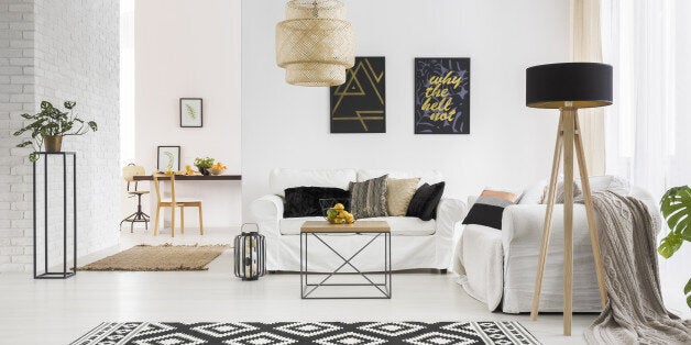 Apartment with white brick wall, sofa, table and pattern rug