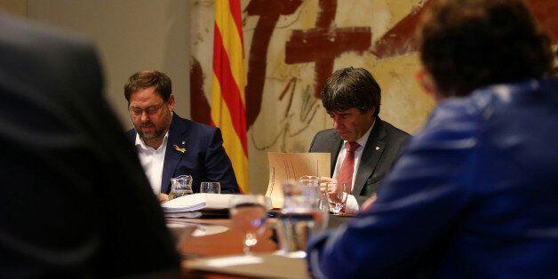 Catalan President Carles Puigdemont (R) and Vice President Oriol Junqueras read documents during a cabinet meeting at Generalitat Palace in Barcelona, Spain, October 24, 2017. REUTERS/Ivan Alvarado