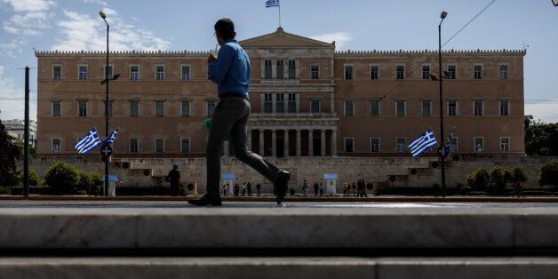 A man walks in front of the Greek Parliament in Athens on May 8, 2017. Greece reached an agreement with its lenders during last week. The weight of this agreement is left on Greek people to carry and especially the pensioners. (Photo by Kostis Ntantamis/NurPhoto via Getty Images)