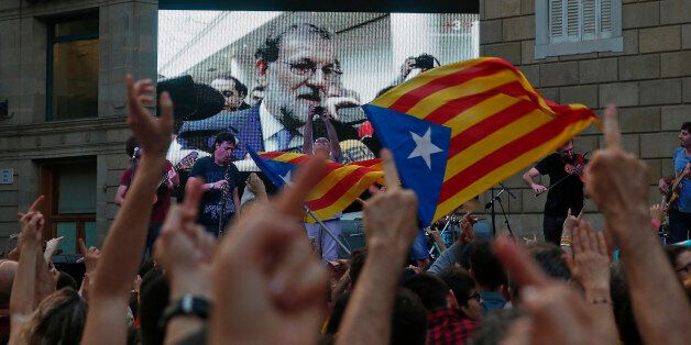 People look at a giant screen broadcasting Spain's Prime Minister Mariano Rajoy during a press statement after an extraordinary cabinet session at Moncloa Palace in Madrid, on October 27, 2017 in Barcelona, Spain. Catalonia's parliament voted to declare independence from Spain and proclaim a republic, just as Madrid is poised to impose direct rule on the region to stop it in its tracks. A motion declaring independence was approved with 70 votes in favour, 10 against and two abstentions, with Catalan opposition MPs walking out of the 135-seat chamber before the vote in protest at a declaration unlikely to be given official recognition. (Photo by Urbanandsport/NurPhoto via Getty Images)