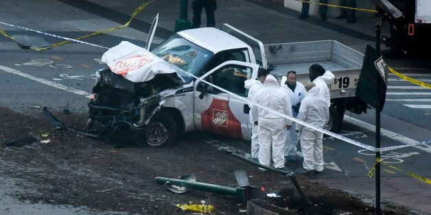 Investigators inspect a truck following a shooting incident in New York on October 31, 2017. Several people were killed and numerous others injured in New York on Tuesday after a vehicle plowed into a pedestrian and bike path in Lower Manhattan, police said. 'The vehicle struck multiple people on the path,' police tweeted. 'The vehicle continued south striking another vehicle. The suspect exited the vehicle displaying imitation firearms & was shot by NYPD.' / AFP PHOTO / DON EMMERT (Photo credit should read DON EMMERT/AFP/Getty Images)